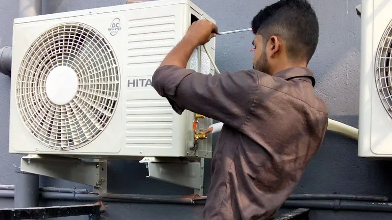 Lahore Home Services technician repairing a split AC outdoor unit
