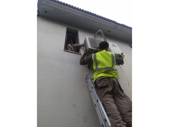 Workman installing outdoor ac